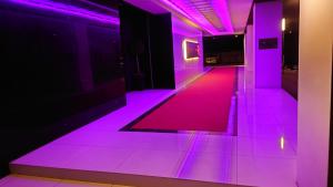 北九州市にあるHotel LOVE MODERNの紫色の照明が床に施された廊下