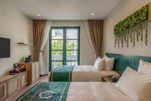 a hotel room with two beds and a window at Bliss Hotel Phu Quoc in Phu Quoc
