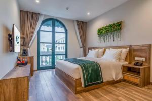 sypialnia z dużym łóżkiem i dużym oknem w obiekcie Bliss Hotel Phu Quoc w Duong Dong