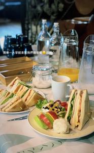 einen Tisch mit zwei Sandwiches und einer Tasse Kaffee in der Unterkunft Wooden 北美莊園 in Miaoli