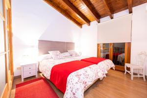 Un dormitorio con una cama grande con una manta roja. en Casa Bella Mirada, en Caimari