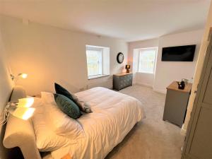 a bedroom with a white bed with two pillows on it at Beautiful House Located Near Kielder Reservoir in Kielder