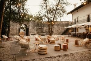 a patio with chairs and tables and a building at Grad Štanjel House in Štanjel
