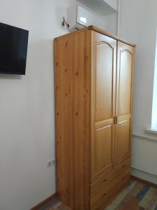 ein Holzschrank in der Ecke eines Zimmers in der Unterkunft Loftik Apartments Gagarin street in Almaty