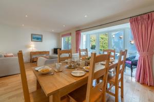 a dining room and living room with a wooden table and chairs at 4 Pentire Rocks in Polzeath