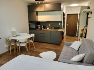 a living room and kitchen with a couch and a table at Apartament 15 z ogródkiem - Pogorzelica in Pogorzelica