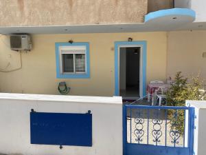 une maison avec une porte bleue et une fenêtre dans l'établissement Galini Apartment, à Karpathos