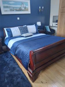 um quarto com uma cama grande e paredes azuis em Tess's Guest House R95K6N1 This Property is unsuitable for children under 12 years old em Freshford