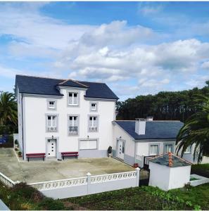 a large white house with a white fence at Casa Arquella in Cartavio