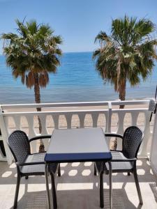 een tafel en stoelen op een balkon met uitzicht op het strand bij Beach front Esther 5 Villajoyosa VACATION RENTALS FROM 11 NIGHTS in Villajoyosa