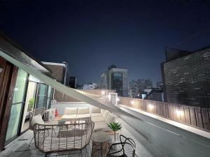 - Balcón con sofá y sillas en un edificio en Dada Stay Hongdae, en Seúl