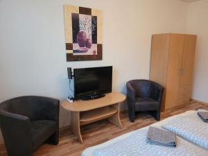 une chambre avec deux chaises et une petite table avec une télévision dans l'établissement Apartmán ROŽŇAVA, à Rožňava