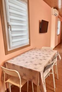 a table and chairs in a room with a window at Apartment Lecer 4 in Porta
