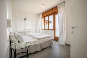 sypialnia z łóżkiem, krzesłem i oknem w obiekcie casa Panoramica w Tremosine Sul Garda