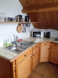 a kitchen with a sink and a microwave at Studio privé aux portes des Fagnes in Polleur