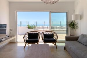 uma sala de estar com um sofá e cadeiras e uma grande janela em INFINITY Sunny Home by Cadiz4Rentals em Cádiz