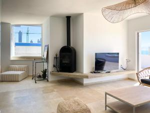 Il comprend un salon avec une cheminée et une télévision. dans l'établissement INFINITY Sunny Home by Cadiz4Rentals, à Cadix