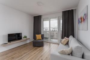 a living room with a couch and a television at Chill Apartments Central Park in Warsaw