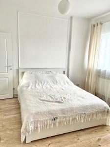 a white bed in a white bedroom with a window at 1Bed Flat Central Bucharest in Bucharest