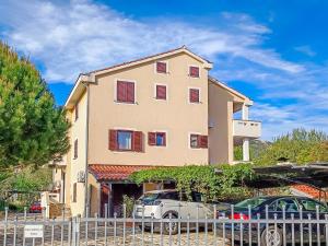ein Haus mit davor geparkten Autos in der Unterkunft Marina in Baška