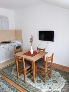 a kitchen with a wooden table with chairs and a tv at Apartman Lazar in Vrnjačka Banja