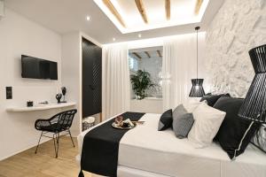 a bedroom with a bed and a table and a chair at Mythos Luxury Suite in Naxos Chora