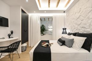 a bedroom with a bed and a table and a chair at Mythos Luxury Suite in Naxos Chora