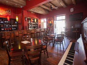 un restaurante con mesas, sillas y un piano en Karoo Art Hotel, en Barrydale