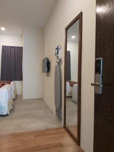 une chambre avec un miroir et une chambre avec un lit dans l'établissement KB HOTEL, à Kepala Batas