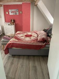 a bedroom with a bed with a red wall at Bürgerstüble in Donaueschingen