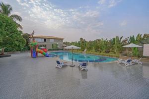 a pool with a slide and chairs and a playground at Sterling Gir in Sasan Gir