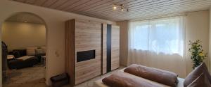 a living room with a couch and a tv and a window at GardenView Apartments & Suites bei Bad Kissingen in Nüdlingen