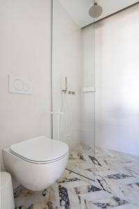 a bathroom with a toilet and a glass shower at Guesthouse Niriides in Spetses