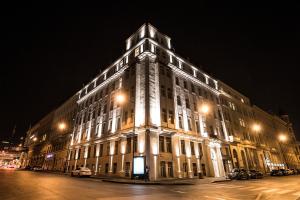 a lit up building on a street at night at The Gold Bank in Prague