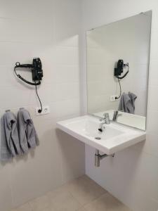 biała łazienka z umywalką i lustrem w obiekcie Apartamentos Tabaiba w Costa Teguise +28 zdjęć