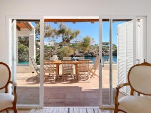 a patio with a table and chairs and the ocean at Villa Guacarachas in Cacla D'or
