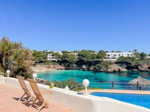a couple of chairs sitting next to a swimming pool at Villa Guacarachas in Cacla D'or
