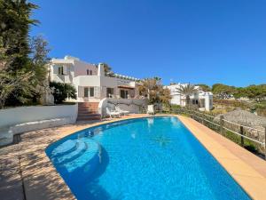 a swimming pool in front of a house at Villa Guacarachas in Cacla D'or