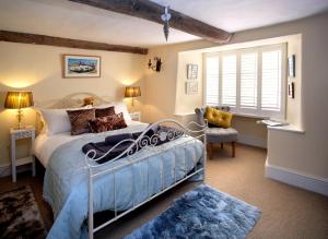 a bedroom with a bed and a chair and a window at The Old Sweet Shop in Minehead