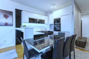 eine Küche mit einem schwarz-weißen Tisch und Stühlen in der Unterkunft Pleasure Lux1 Apartment in Belgrad