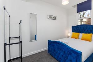 a bedroom with a blue bed and a window at FLATZY - Stylish Abode on Doorstep of Sefton Park *10 minutes to Centre* in Liverpool