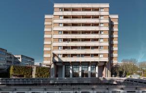 un edificio alto con una fuente frente a él en UXCO Grenad'inn, en Burdeos