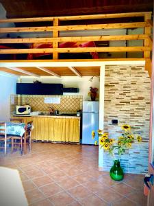 a kitchen with a vase of flowers on a tile floor at Lovely Cottage in Castellammare del Golfo