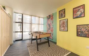 una habitación con una mesa y algunas fotos en la pared en UXCO Grenad'inn, en Burdeos