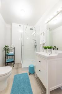 a white bathroom with a toilet and a sink at Apartament Kasztelan in Ustrzyki Dolne