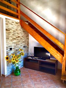 a living room with a tv and a staircase at Lovely Cottage in Castellammare del Golfo