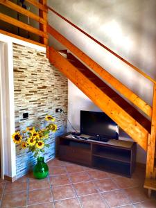 een woonkamer met een tv en een trap bij Lovely Cottage in Castellammare del Golfo