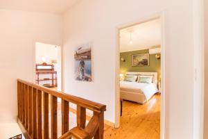 a bedroom with a bed and a hallway with a staircase at Grand Skylight in Corfu Town