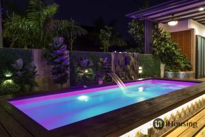a pool in a backyard at night with a fountain at Private Pool Platinum House Melaka By I Housing in Melaka