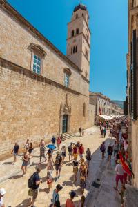 un groupe de personnes marchant devant un bâtiment dans l'établissement Kenova apartment Old Town, à Dubrovnik